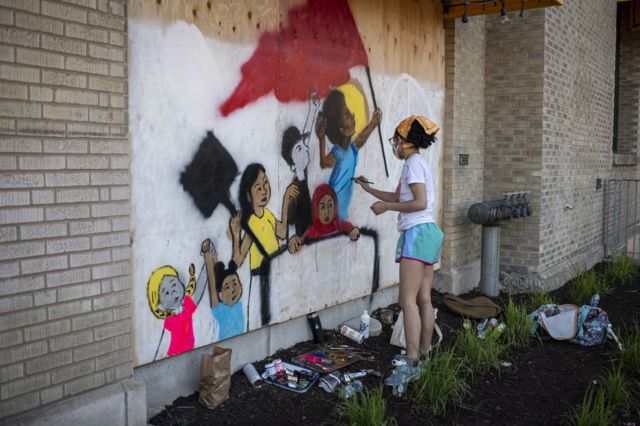 18. A woman paints a mural during protests resulting from the killing of an unarmed black man, George Floyd, by police.