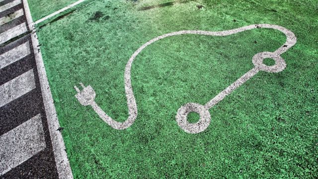 Símbolo de um carro elétrico com tomada pintado no asfalto