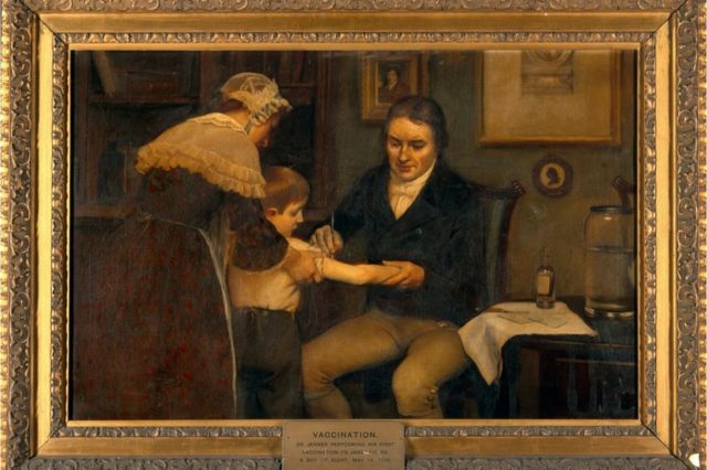 Oil painting in a gold frame depicting Edward Jenner administering his first vaccination to a young boy James Phipps