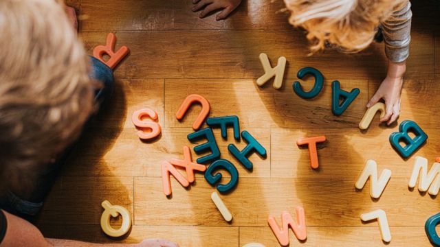 Два ребенка пытаются складывать слова из букв