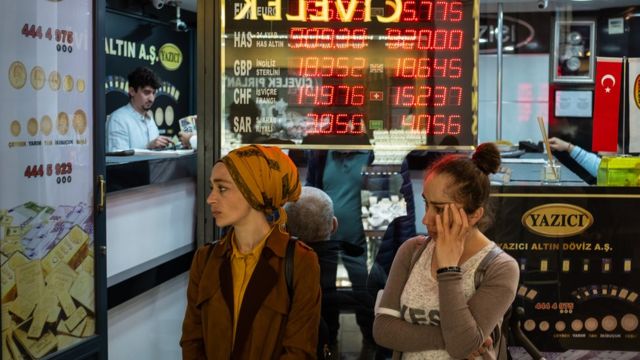 La gente se para junto a una oficina de cambio en el Gran Bazar de Estambul el 5 de mayo de 2022 en Estambul, Turquía.  La tasa de inflación subió a casi el 70% (69,97%) en un año en abril en Turquía, la tasa más alta desde febrero de 2002 según cifras oficiales publicadas el 5 de mayo.
