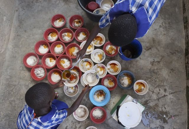 Two children dish out food