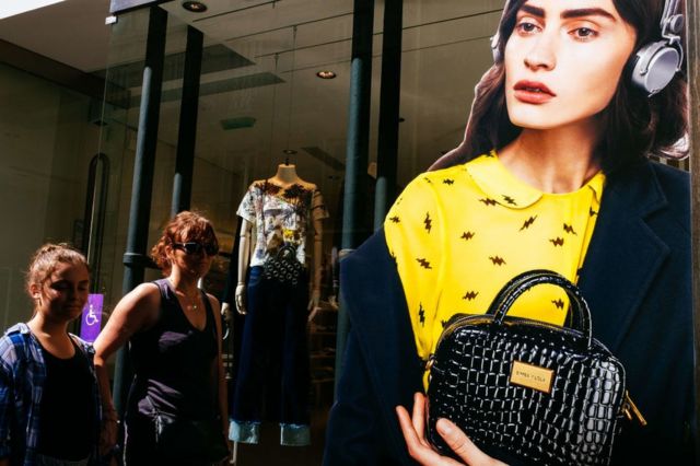 Mulheres passam em frente a uma vitrine em Paris