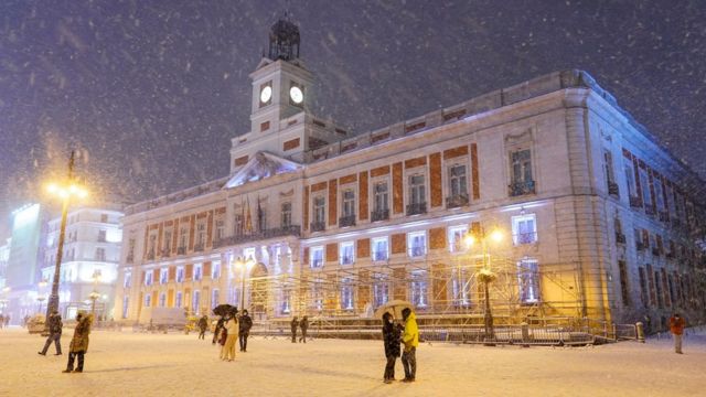 Gente camina en la nieve en la Puerta del Sol, Madrid