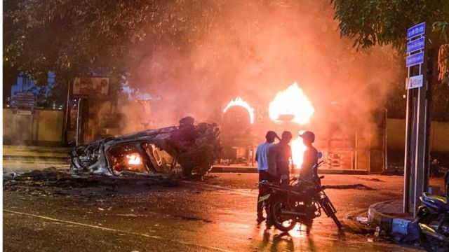 A vehicle belonging to the security personnel and a bus set alight is pictured near Sri Lanka's outgoing Prime Minister Mahinda Rajapaksa's official residence in Colombo 9 May 2022.