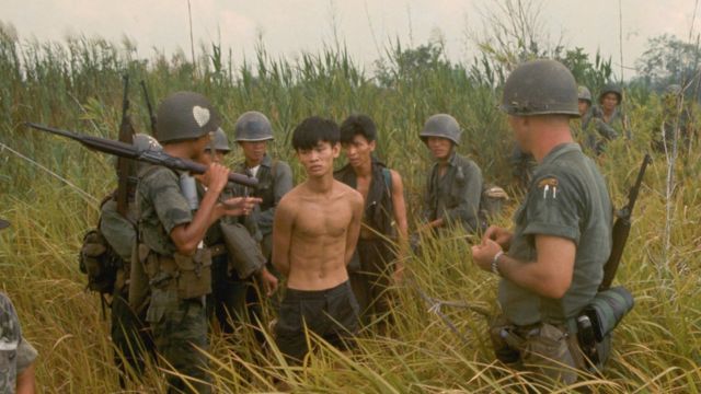 A group of South Vietnamese army soldiers and an American soldier with two captured Vietcong suspects.