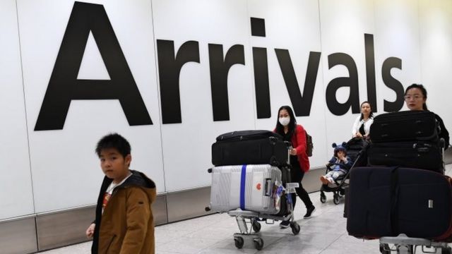 Pessoas chegando em aeroporto no Reino Unido
