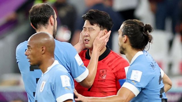 El capitán de la selección uruguaya, Diego Godín, toma con sus manos el rostro del futbolista surcoreano Son Heung-min.
