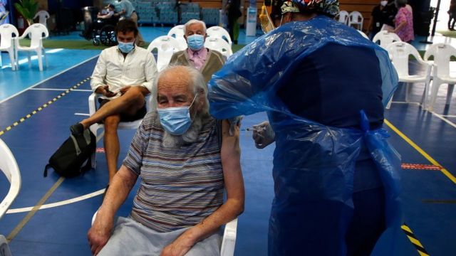 Personas recibiendo la vacuna en un gimnasio en Chile.