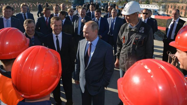 Vladimir Putin rodeado de obreros