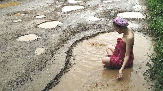Woman bathing in pothole