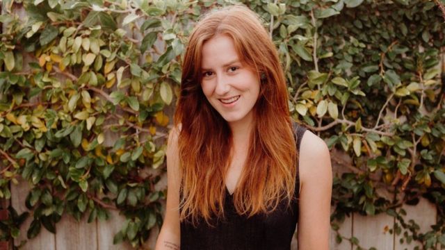 Kate Hall standing against a leafy wall