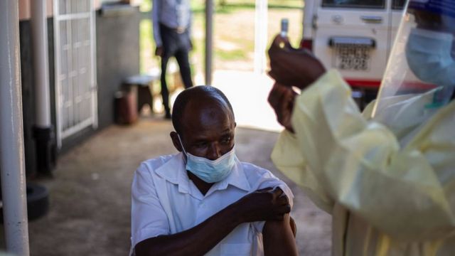 Uma enfermeira se prepara para obter a vacina em uma clínica de aldeia perto de Chinhoyi, Zimbábue, fevereiro de 2021