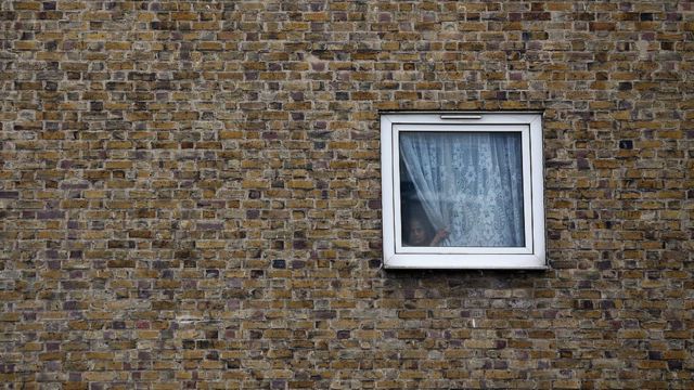 Una niña mira por la ventana de una vivienda social de Tower Hamlets, en el este de Londres.