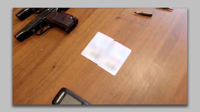 Identités floues de deux Marocains sur une table à côté de deux pistolets et balles