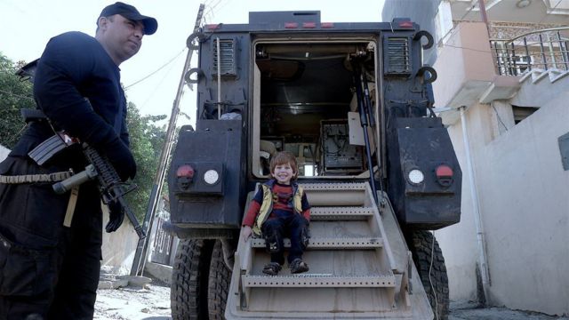 طفل عراقي يعتلي مركبة عسكرية