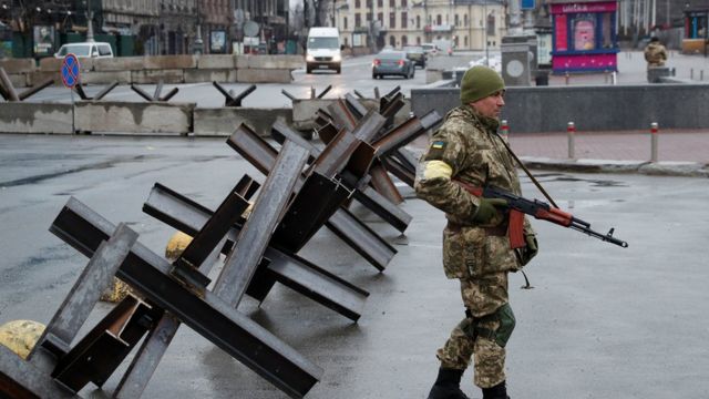 Um membro das Forças de Defesa Territoriais guarda um posto de controle, na Praça da Independência, no centro de Kiev