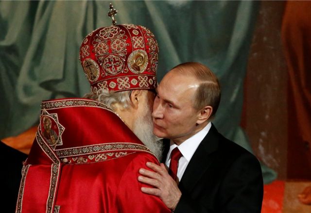 El patriarca Kirill, quien encabeza la Iglesia ortodoxa rusa, abraza al presidente de Rusia, Vladimir Putin, durante la misa de la Pascua ortodoxa, el 16 de abril de 2017.