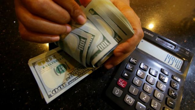 Petugas menghitung uang pecahan dolar Amerika Serikat