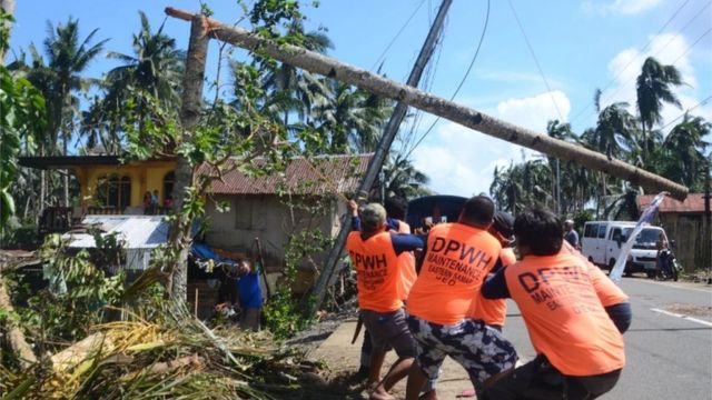 Los trabajadores tiran de un pilón eléctrico caído dañado a la altura del tifón Phanfone en la ciudad de Salcedo, en la provincia de Samar Oriental, el 26 de diciembre de 2019.