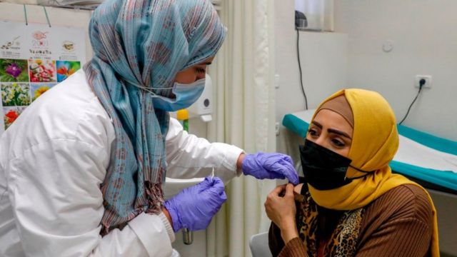 Una mujer palestina recibe una vacuna de covid