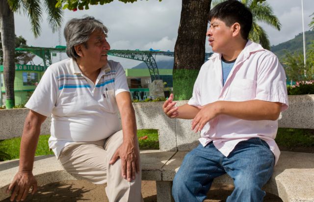 Roger Zapata e Luis Fermn Tenorio Cortez em 2018 sentados no banco de uma praa em Pichanaki conversando