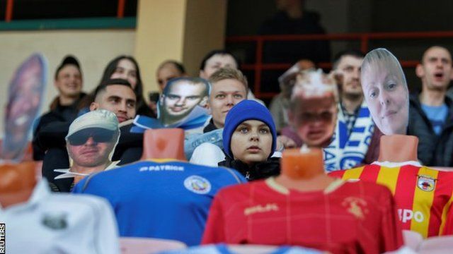 Fans in the stands with mannequins of virtual ticket holders