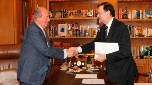 O primeiro-ministro espanhol, Mariano Rajoy (à direita), cumprimenta o rei Juan Carlos, que abdicou do trono após 40 anos