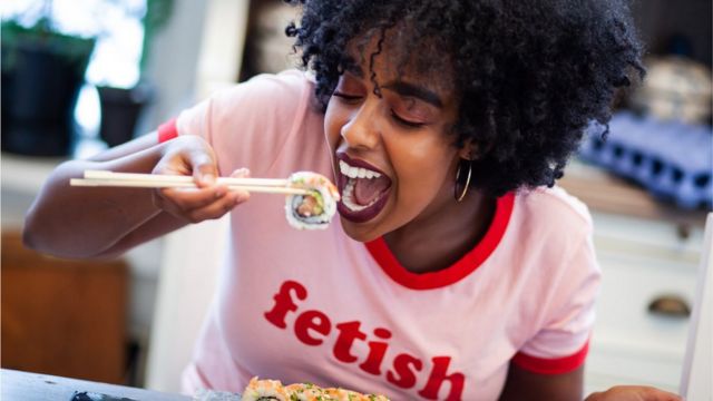 Une femme qui mange du sushi