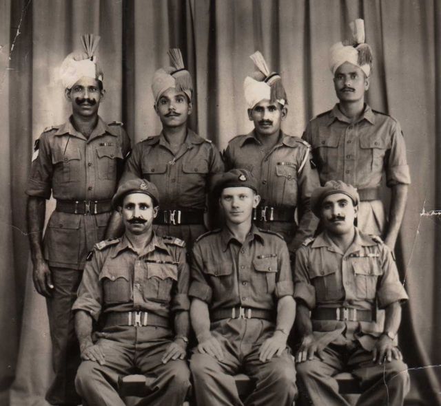 Robin Rowland sentado ao centro com membros do regimento de Punjab após a derrota japonesa em foto tirada em Bangkok em 1945