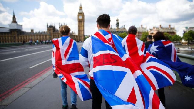 Simpatizantes de la opción "Salir" cubiertos en banderas británicas caminan hacia el parlamento