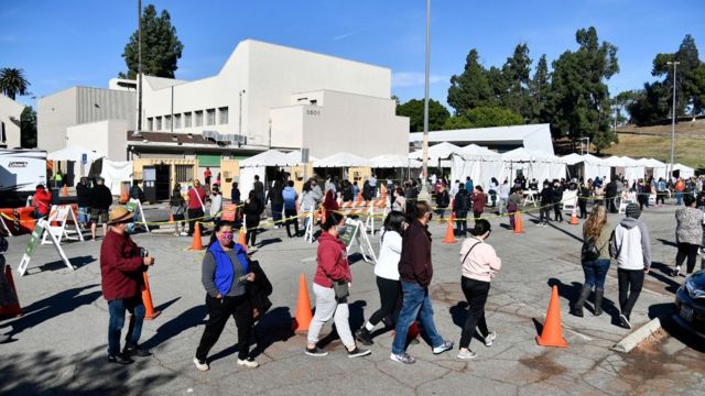 Pessoas com máscaras fazem fila para vacinação em tendas médicas em Los Angeles