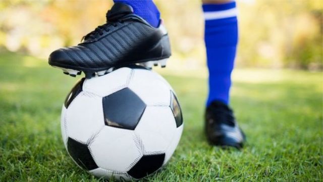 Jogador De Futebol Pronto Para Jogar Com a Bola De Futebol Foto de