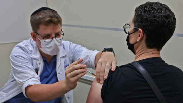 Trabajador de la salud vacunando una persona en Israel
