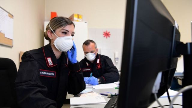Dos personas con mascarillas en una oficina