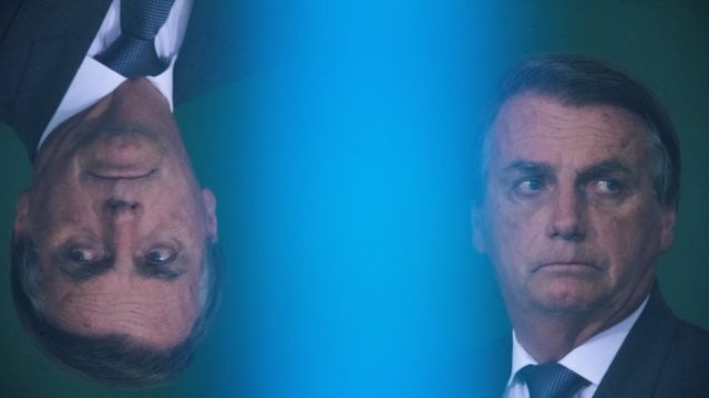 Bolsonaro com feição séria e reflexo