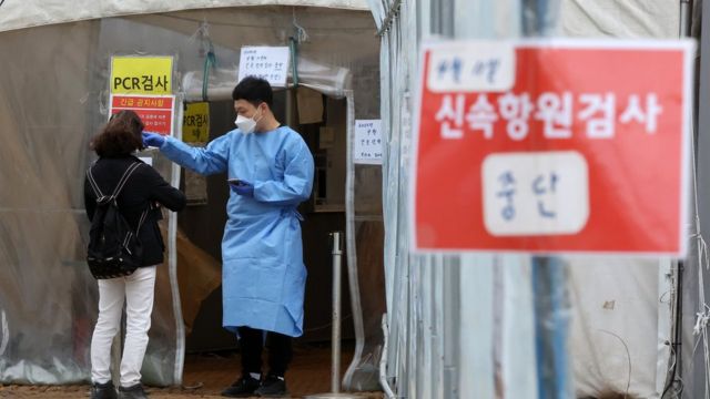No dia 14, uma pessoa encarregada do centro temporário de testes de triagem na Estação Yongsan, em Seul, forneceu informações sobre o teste COVID-19.