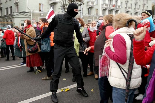 Belarusian pensioners argue with a law enforcement officer during a rally to demand the resignation of Alexander Lukashenko and new fair election in Minsk on 12 October 2020