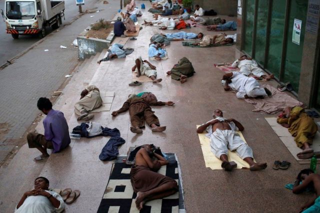 Orang-orang tidur di trotoar untuk menghindari panas dalam ruangan di Karachi, Pakistan.