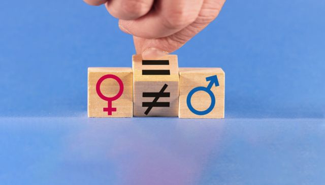Imagen de dos cubos con los signos de los géneros entre un tercero que tiene el símbolo de igualdad o desigualdad