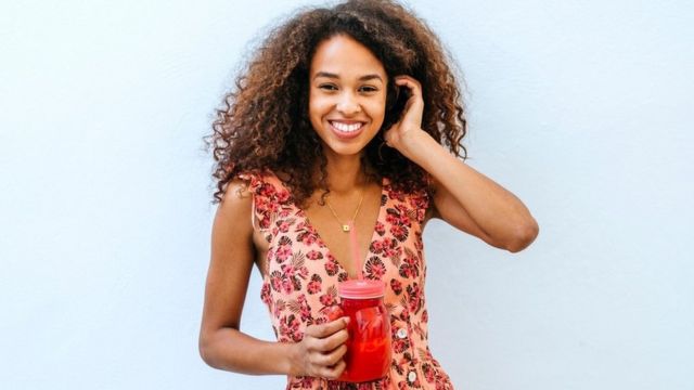 A young girl with a smoothie in her hand