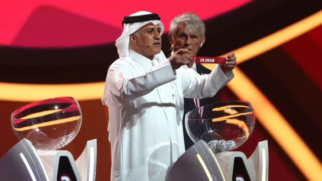 El ex jugador de fútbol qatarí Adel Ahmed Mallala mostrando el nombre de Irán durante el sorteo de la Copa Mundial de Fútbol