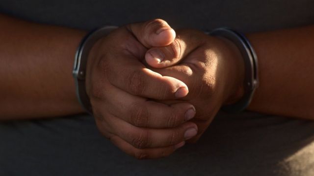 руки в наручниках одного из задержанного в ходе рейдов против "Мара Сальватруча"