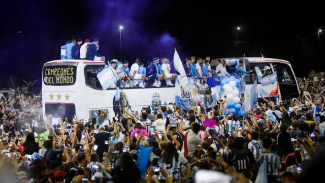 La selección nacional de fútbol de Argentina a bordo de un autobús, seguido de aficionados