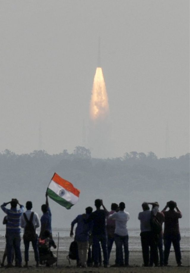 Indian onlookers watch the launch of the Indian Space Research Organisation (ISRO) Polar Satellite Launch Vehicle (PSLV-C37) at Sriharikota on 15 February 2017.