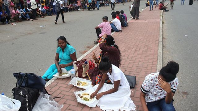 People eat food, as they wait to apply for passports at the Sri Lanka Immigration and Immigration Department in Colombo, Sri Lanka, on July 07, 2022, amid the country's economic crisis