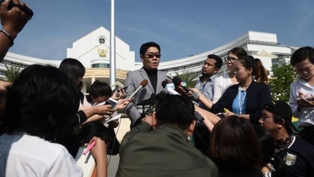 Kong Suriyamontol (C-with sunglasses), the Thai lawyer for Japanese national Mitsutoki Shigeta, speaks to the press after his client was granted paternity rights to his children, at a juvenile court in Bangkok on February 20, 2018.