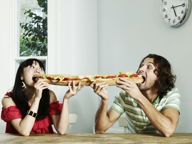 Casal dividindo um sanduíche na baguete