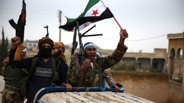 Rebeldes sírios apoiados pela Turquia levantam a bandeira da oposição Síria na cidade de Qirata em dezembro de 2018