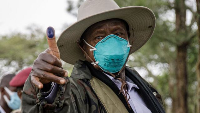 Ugandan President Yoweri Museveni holding up his ink-marked thumb after voting - Thursday 14 January 2021
